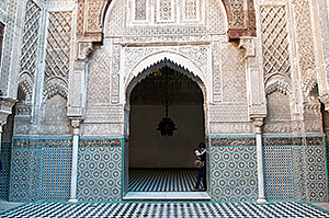 Foto av Al-Qarawiyyins gård och öppning med kakelmosaik i beige och blå toner
