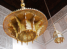 Foto av tjusiga lampor i guld och med beige kakel i mosaik i bakgrunden