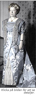 Foto av Selma Lagerlöf iförd en vecker klänning från Augusta Lundins. Den går i blått och vitt, med sidensläp. Under bilden står det: "Klicka på bilden för att se detaljer".