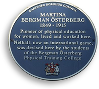 Rund blå plakett med gul text: Martina Bergman Österberg 1849 - 1915, Pioneer of Physical education for women, lived and worked here. Netball, now an international game, was devised here by the students of the Bergman Österberg Physical Training College.