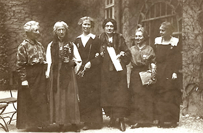 Foto av sex kvinnor i helfigur med långa klänningar