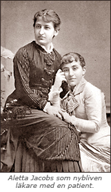 Foto av Aletta Jacobs som sitter på en stol och en annan ung kvinna som tycks sitta på golvet och luta sig mot Alettas knä. Den andra kvinnan ser in i kameran, Aletta ser åt vänster. Under bilden står: Aletta Jacobs som nybliven läkare med en patient.