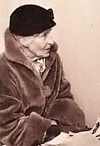 Foto av Elin Brandell på äldre dar. Hon sitter iförd päls och mörk hatt med ansiktet åt höger.