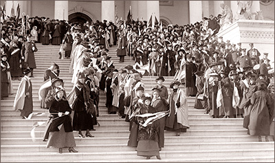 Foto av massor av kvinnor som står med fanor i trappan till Kapitoleum