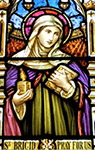 Foto av del av ett glasmosaikfönster med en bild av Saint Brigid i klara, starka färger