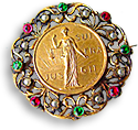 IWSA-brosch i filigran med vita, röda och gröna pärlor, i mitten IWSA:s logotyp med Justitia i soluppgången och texten JUS SUF FRA GII