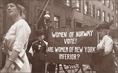 Foto av kvinnor som demonstrerar. På banderollen står det: Women of Norway vote! Are women of New York inferior?
