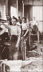 Foto av fyra kvinnor som står i en fabrik, det ligger kedjor runt om.