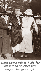Foto av två kvinnor i hatt som håller i varsin arm på en tredje, äldre kvinna, som ser ut att ha svårt att gå. Under står texten: Dora Lewis fick ta hjälp för att kunna gå efter fem dagars hungerstrejk