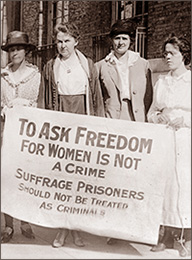 Foto av fyra kvinnor som står ute på gatan. De håller upp en banderoll där det står: To Ask Freedom för Women is Not a Crime - Suffrage Prisoners Should Not be Treated as Criminals