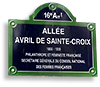 Foto av en gatuskylt i  typiskt franskt grönt, blått och vitt, med texten Alleé Avril de Sainte-Croix