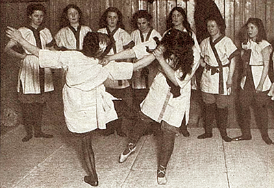 Foto från Edith Garruds dojo av sju tjejer som tittar på när två andra tränar