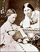 Foto av Millicent sittande vid ett bord med en bok i händerna, medan Agnes lutar sig över bordet med huvudet vilande i ena handen