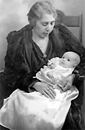 Foto av prinsessan Sofia på äldre dar, sittande med babyn Drovna i knäet. Hon tittar ner mot babyn.