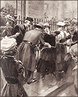 Illustration av suffragetter som kedjat fast sig vid ett metallstaket och poliser som försöker ta loss dem samt åskådare runt omkring