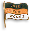 Utsirat rockmärke/brosch i form av en flagga med texten Votes for Women på tre rader med färgerna grönt, gult och vitt bakom