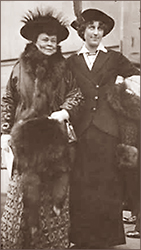 Foto av två kvinnor utomhus, iförda kappor och diverse pälstillbehör