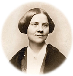 Porträttfoto av Lucy Stone med uppsatt hår. Hon ser snett åt sidan och ler