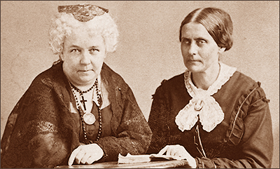 Foto i halvfigur av Elizabeth Cady Stanton och Susan B. Anthony. Elizabeth ser rakt in i kameran, medan Susan tittar snett åt sidan.