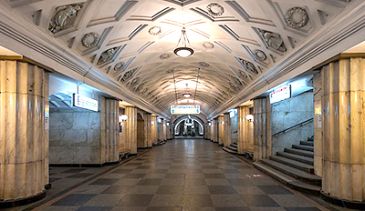 Foto av en vy över tunnelbanestationen, med trappor på högra sidan och gångar på den vänstra. I taket syns porslinsfigurer. Längre in mot mitten är en stor vit informationstavla med blå och röd text, men det syns inte vad det står på den