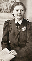 Fot av ung Margaret Bondfield sittande med några papper i handen