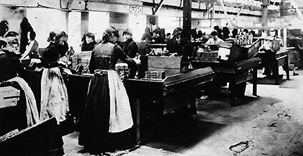 Foto inifrån fabriken cirka 1890, en massa tjejer och kvinnor står och fyller tändsticksaskar