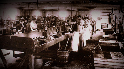 Foto inifrån frabriken Bryant & May cirka 1890. Många kvinnor och flickor står och jobbar, troligen med tändsmeten.