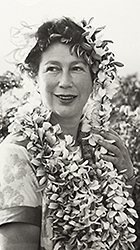Foto av Anna Riwkin på äldre dar, under en reportageresa till Hawai, vilket förklarar kransarna runt hennes huvud och hals