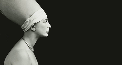 Dramatiskt självporträtt av Anna Riwkin i profil iförd en strut på huvudet  mot en helt svart bakgrund