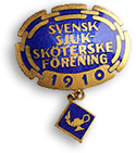 Brosch i blått och guld med texten "Svensk Sjuksköterskeförening 1910"