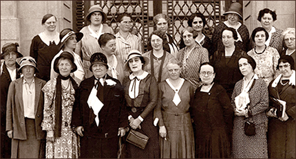 Gruppfoto av kvinnor som står i tre rader bakom varandra, de flesta har hatt men inte kappa