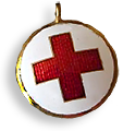 Foto av ett gammaldags hänge med guldkant och i mitten ett rött kors på vit botten