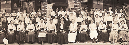 Foto av massor av kvinnor med standar, de längst fram sitter, de andra raderna tycks stå. 