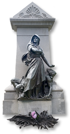 Foto av monumentet över Haymarket-martyrerna, en stor grå smyckad pelare med en kvinna som står rak framför en man som ligger böjd bakom henne, datumet "1887" står i relief på sockeln
