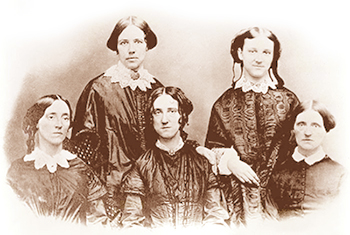 Tidigt foto av Maria Mitchell och hennes fyra systrar. De är alla klädda i mörka 1800-talskläder med vita spetskragar runt halsen. Alla utom den längst till vänster ser in i kameran.