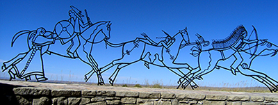 Monument i form av siluetter i metall av hästar och siouxer och cheyenner 