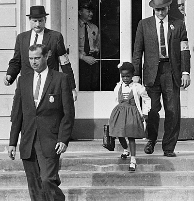 Tre federala polisen omger den lilla Ruby Bridges som är på väg nedför en trappa.