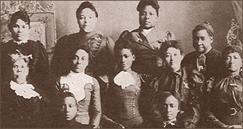Foto av elva kvinnor som står i tre rader bakom varandra