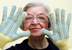 Porträttfoto av Kwolek som håller upp handskförseddan händer framför ansiktet