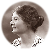porträttfoto av Margaret Bondfield i profil vänd åt vänster. Hon har en spetskrage och uppsatt hår