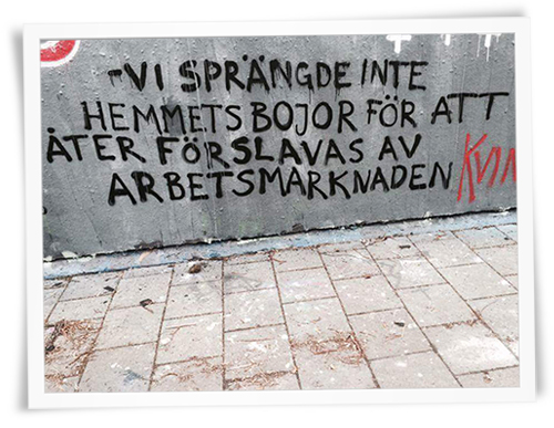 Foto av grafitti med texten Vi sprängde inte hemmets bojor för att åter förslavas av arbetsmarknaden.