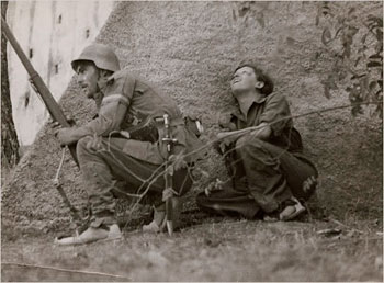 Gerda Taro bakom en soldat, fotograferad av Robert Capa i Spanien 1937