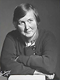 Foto av Eva Andén på äldre dar. Hon sitter lutad på armarna, med armarna i kors