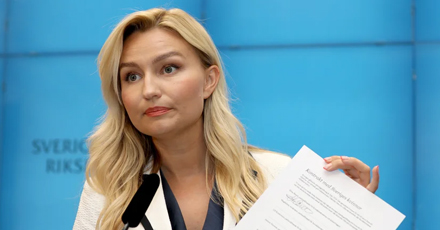 Foto av Ebba Busch som håller upp ett abortkontrakt